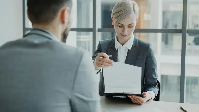 Dos personas revisando un documento en una entrevista